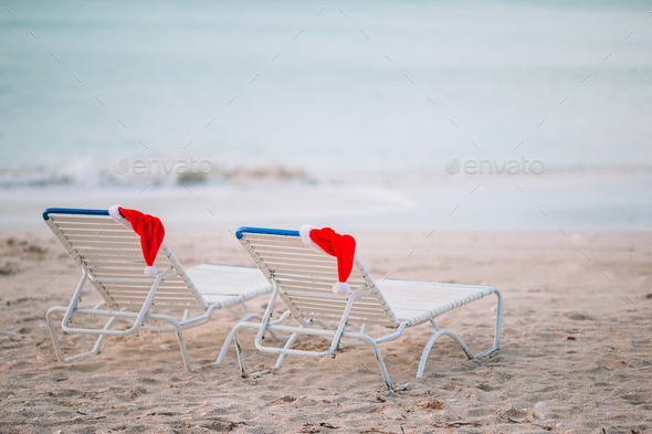 Closeup santa hat on chair on tropical white beach - Stock Photo - Images