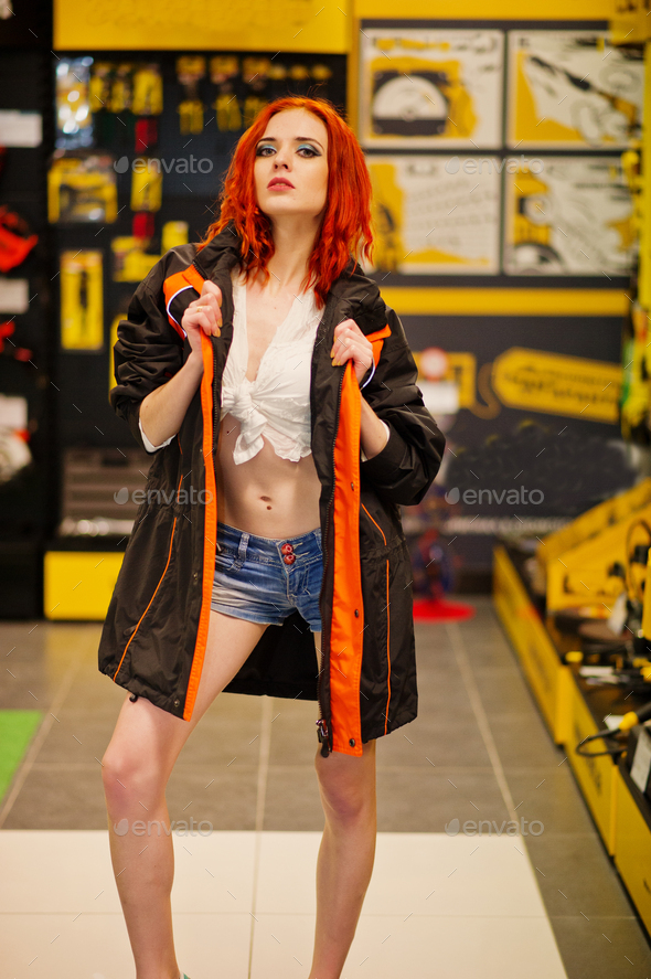 Red haired model posed weared on working jacket at store or household shop of working tools.