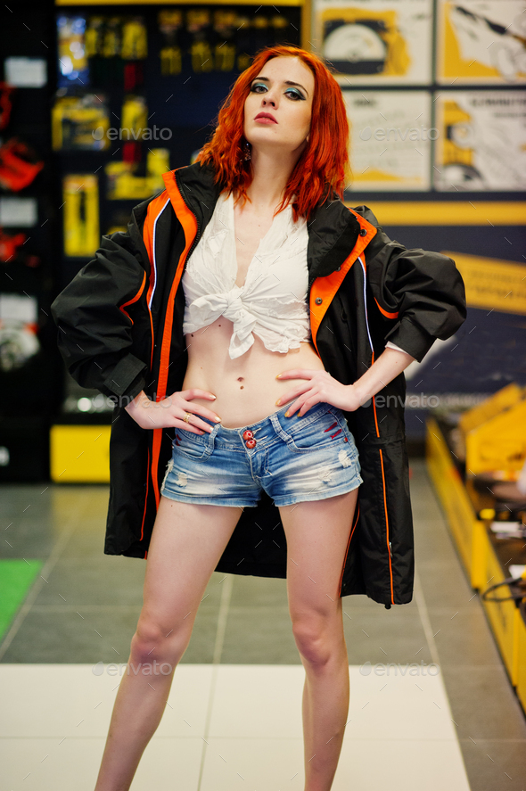 Red haired model posed weared on working jacket at store or household shop of working tools.