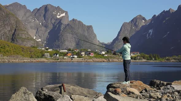 Woman Fishing on Fishing Rod Spinning in Norway alt