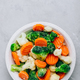 Frozen vegetables. Frozen carrots, broccoli and cauliflower in bowl on gray stone background - PhotoDune Item for Sale