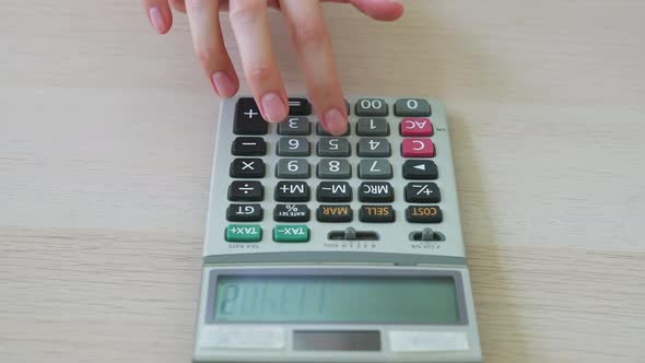 Hand press calculator to calculate income expenses and plans for spending money on home office alt