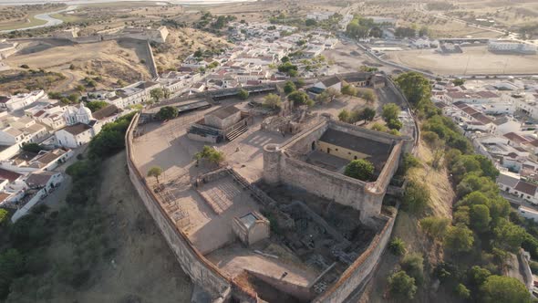 Aerial above view of hilltop defensive Castro Marim castle surrounded by parish village. alt