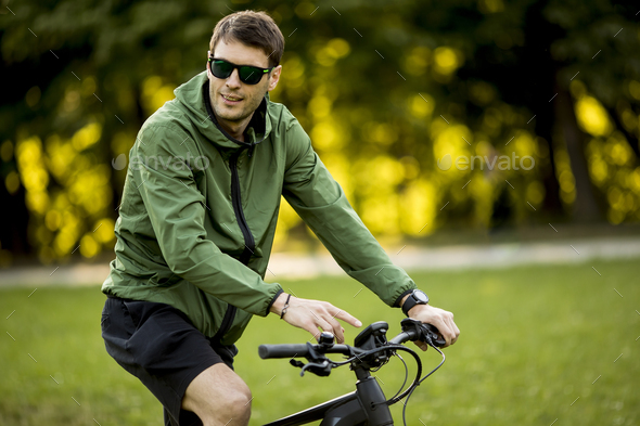 Young man riding ebike in nature - Stock Photo - Images