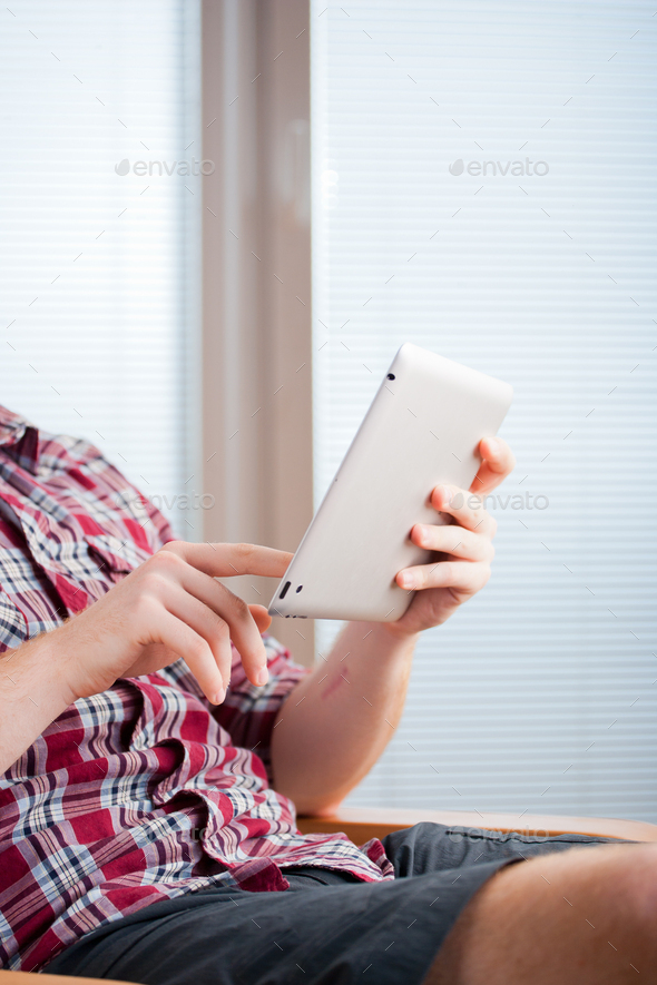 Focused man working and playing with tablet computer (lots of copyspace) - Stock Photo - Images