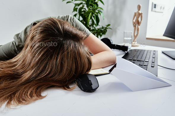 Woman sleeps at home office workplace, Overworking burnout