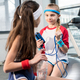 two little girls in sportswear sitting at fitness studio, children