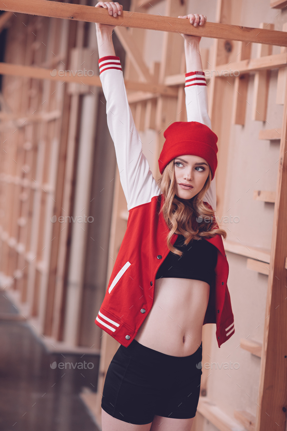 Stylish hipster woman in baseball jacket and red hat