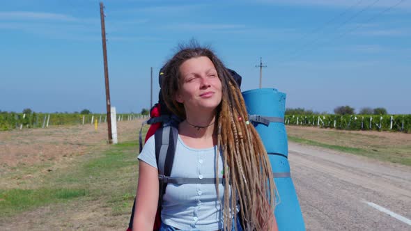 Girl with Dreadlocks Goes Past Vineyards alt