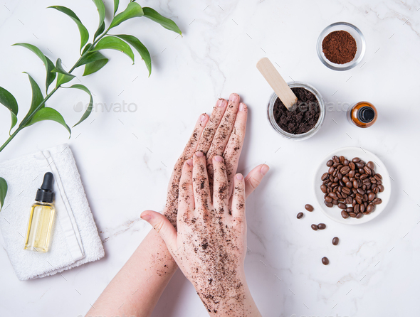 A young woman does a hand massage with a homemade coffee scrub from recycle capsule with olive oil