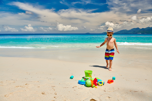 Three year old toddler playing on beach - Stock Photo - Images