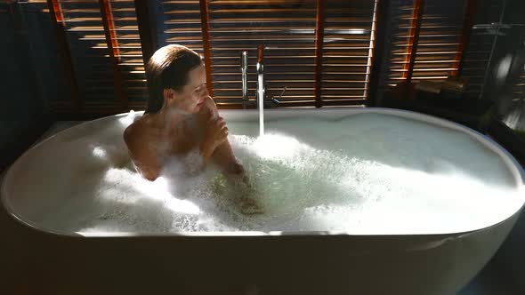 Sexy Sensual Woman Relaxing Close Her Eyes and Take a Bath in Bathtub with Foam alt