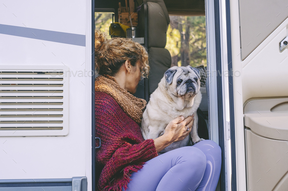Living off grid lifestyle with woman and her best friend dog sitting and relaxing on the door