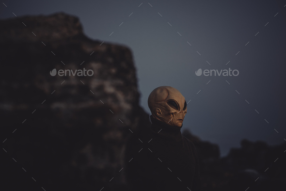 Portrait of alien head in a dark outdoors nature background. Concept of aliens among us.