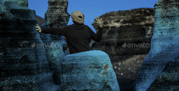 Blue night and alien ufo mask between rocks. Concept of aliens among us. Space discover
