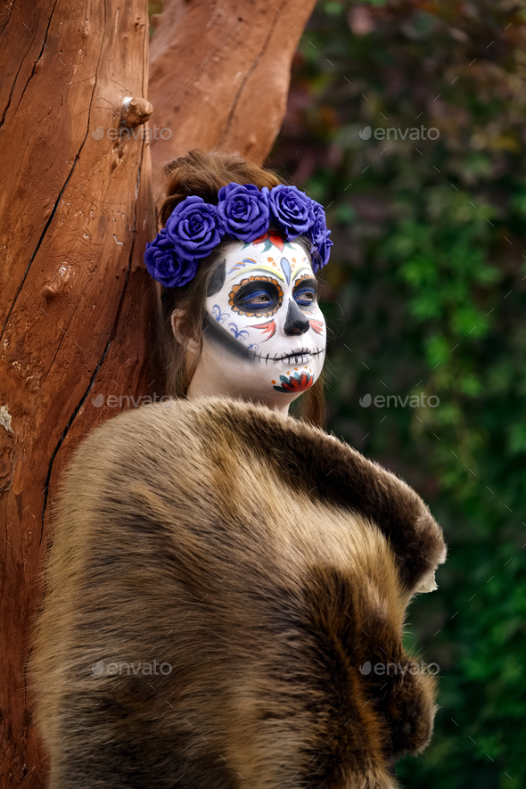 Female daemon in sugar skull makeup outdoor. Face painting art.