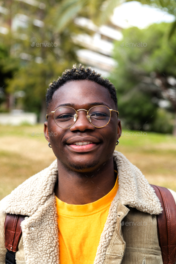 Headshot of confident African American college student with eyeglasses looking at camera. Vertical - Stock Photo - Images