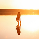 A loving couple looks at each other, hugs, kisses, standing in the water of the lake in the sunset - PhotoDune Item for Sale