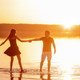 Silhouette of a couple in love, dances with splashes in the water of the lake in the orange sunset - PhotoDune Item for Sale
