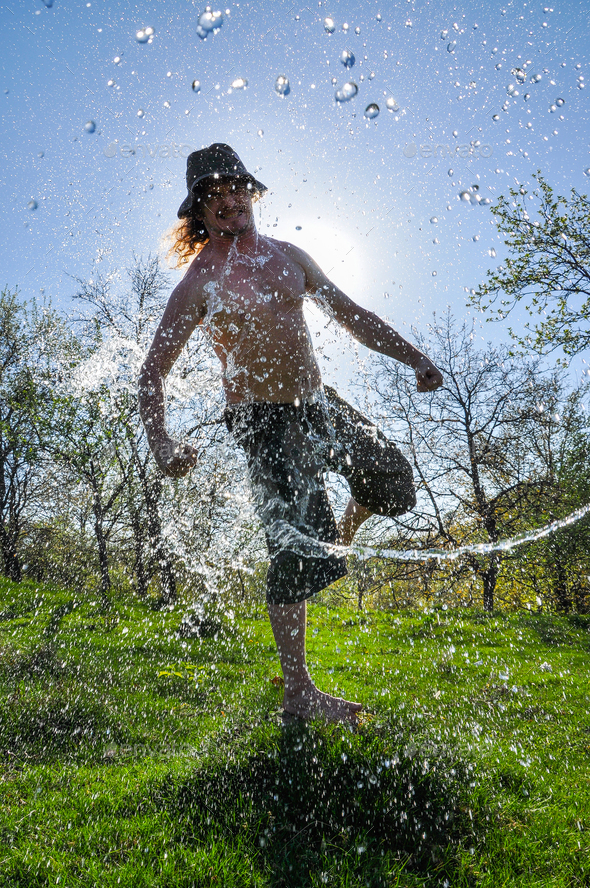 Ice bucket challenge. Man pours iced water from a bucket Stock Photo by salajean