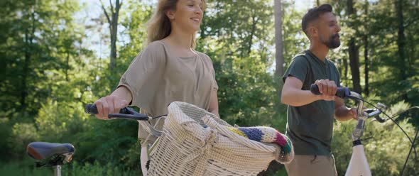 Video of couple pushing bicycle on a sunny day. Shot with RED helium camera in 8K. alt