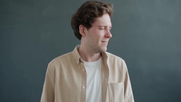 Portrait of Attractive Young Man Shaking Head Saying NO Looking at Camera on Gray Background alt