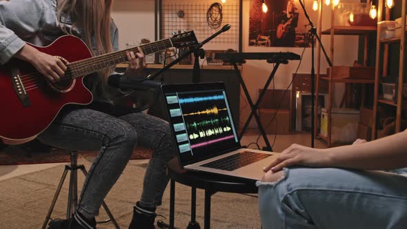 Female Guitarist Recording Music In Studio alt