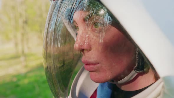 Emotionless spacewoman staring through helmet visor, side view