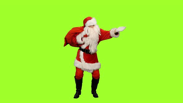 Santa Goes with Gifts Bag and Looks Into the Distance on Green Background