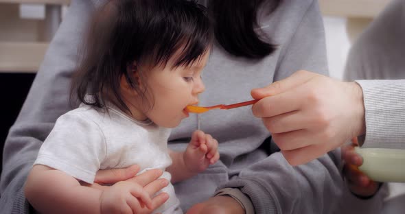 Young Parents Give Healthy Food to Baby Baby's First Food