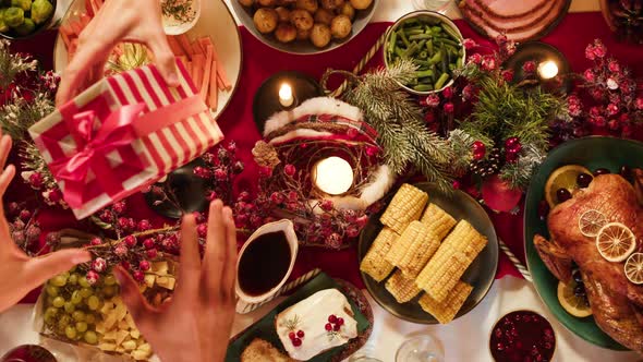 Friends Giving Presents to Each Other Top View Celebrating New Year Sitting at Dining Table alt