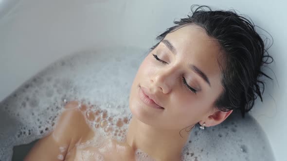 Close Up Relaxed Woman Touching Skin with Foam in Bath