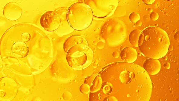 Super Slow Motion Shot of Moving Oil Bubbles on Golden Background at 1000Fps alt