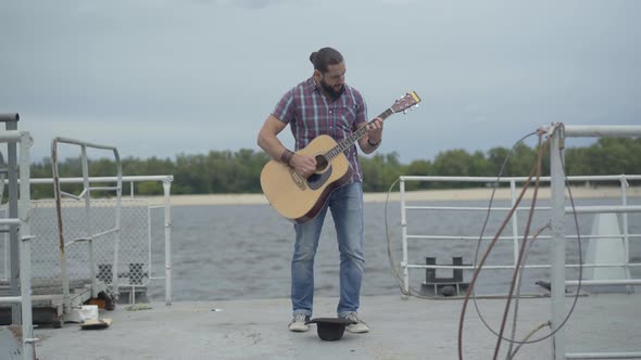 Wide Shot of Angry Musician Stop Playing Guitar and Hitting Hat with Leg. Portrait of Unhappy alt