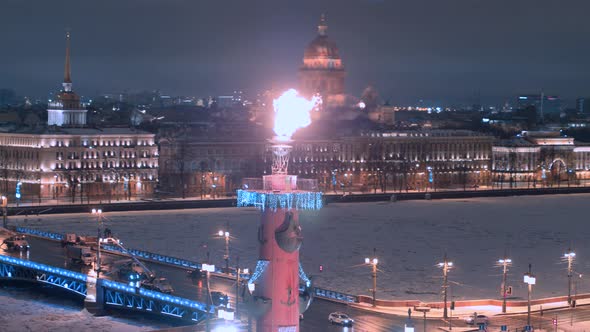 Rostral columns with a lit torch in Saint Petersburg winter time. alt