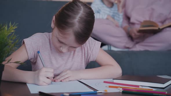 Cute Girl Is Sitting in Front Side Close View and Drawing Creative Way with Crayons.
