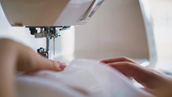 Hands of Young Woman Sews alt