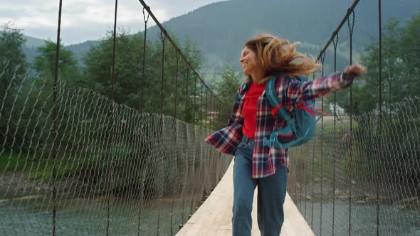 Happy Traveler Jumping Mountains on River Bridge alt