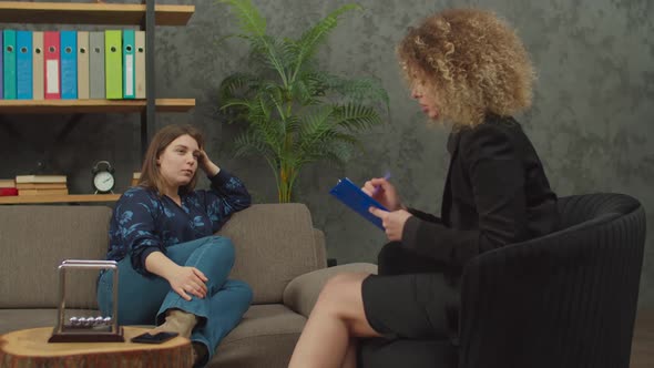 Worried Woman Having Counseling Session with Female Psychotherapist at Clinic alt