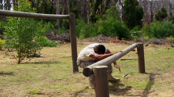 Military solider running over hurdles during obstacle course 4k alt