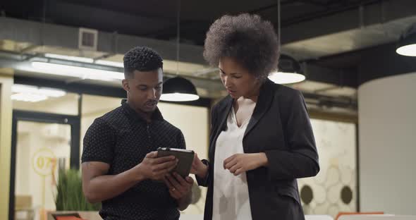 Black Employees Discussing Data on Tablet alt