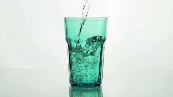 Сrystal Clear Water Pouring Into Green Faceted Glass alt