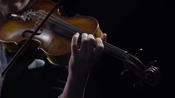 Violinist Holds a Bow and Plays. Black Background. Close Up alt