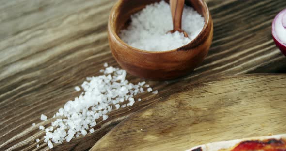 Italian pizza on wooden table with vegetables and spices alt