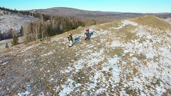 Aerial  Middleaged Couple Go Hiking in the Alpine Winter Mountains alt