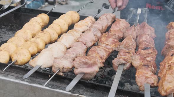 Shish Kebab and Mushrooms on Skewers Cooked on Barbecue at Street Food Festival alt