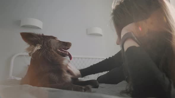 Young Woman In Bed With Her Dog alt