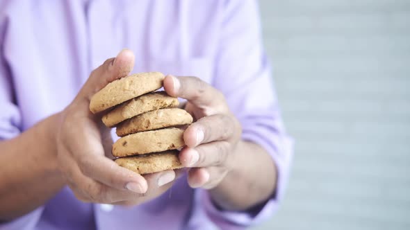 Hand Holding Stack of Whole Meal Cookies with Copy Space alt