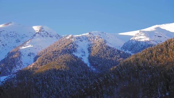 Snow Covered Beautiful Mountain Peaks Against the Blue Sky alt