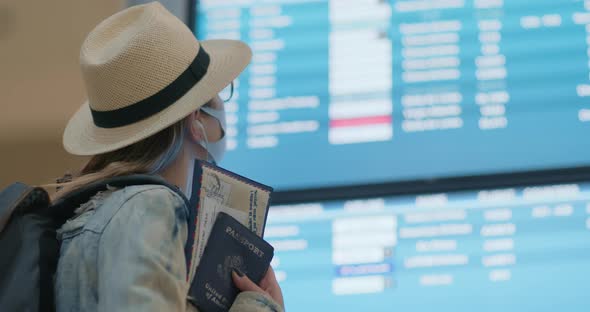 Woman Looking at Flight Timetable and Searching Flight in Airport Terminal alt